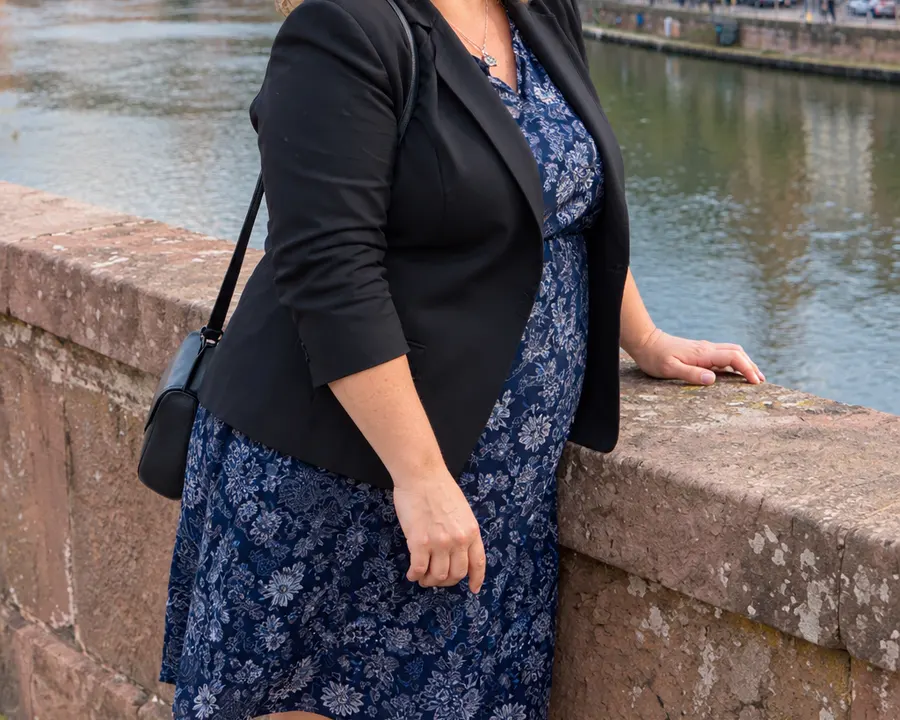 Schwarzer Blazer über einem blau geblümten Kleid